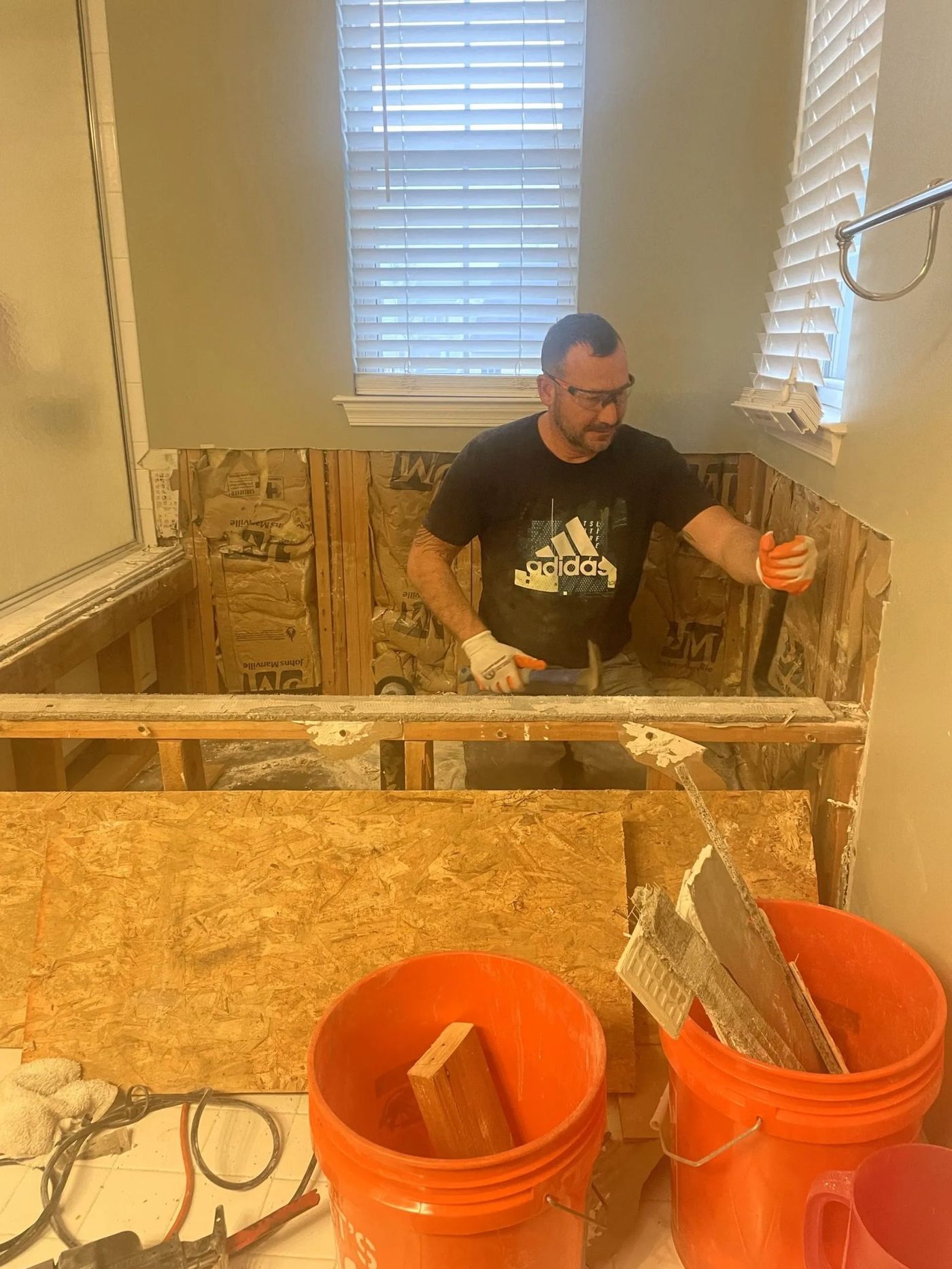 Matt framing a tiled shower bench during a bathroom remodel